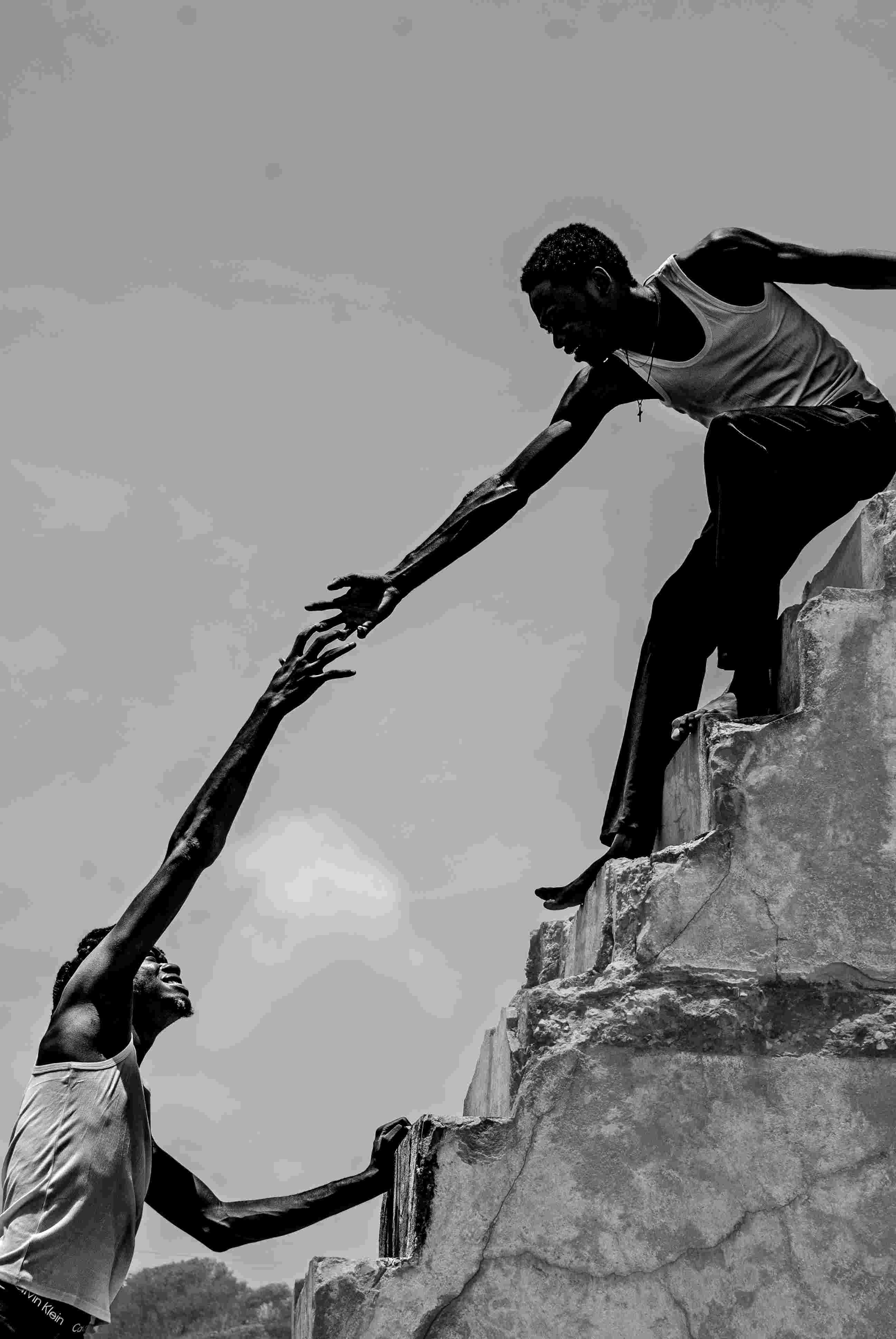 Two men reaching for each others hand