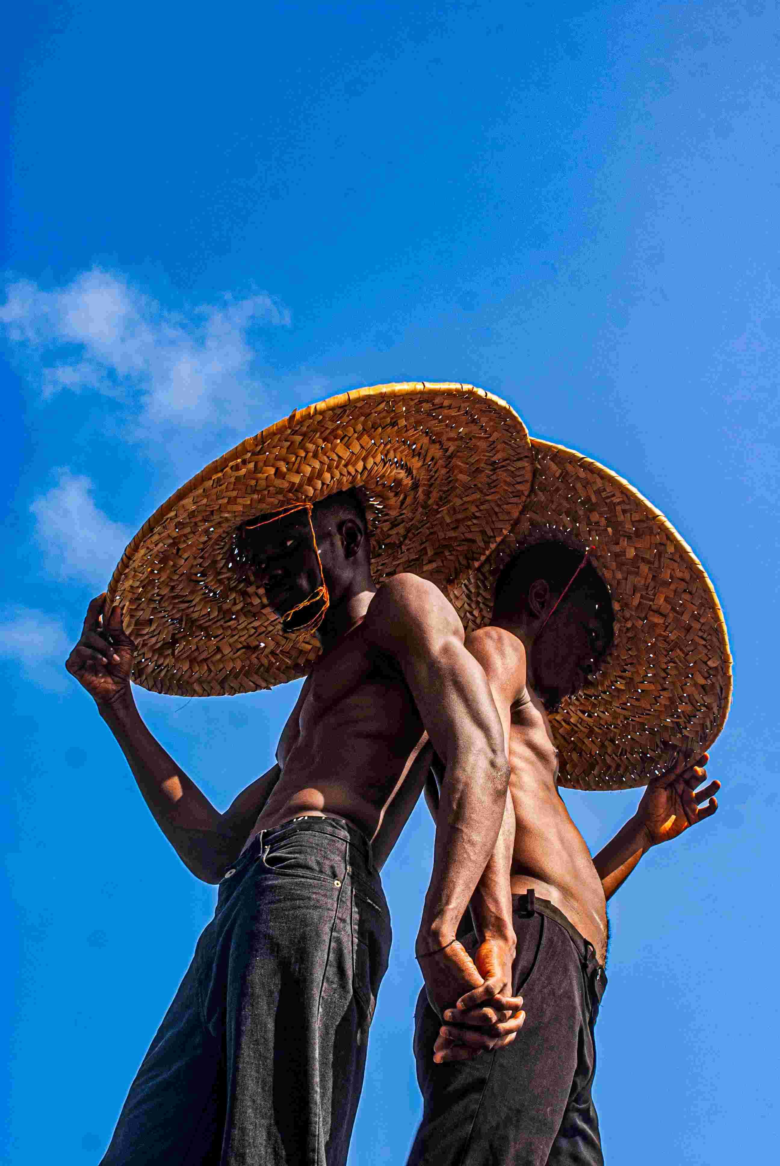 Two guys in hats with backs against each other