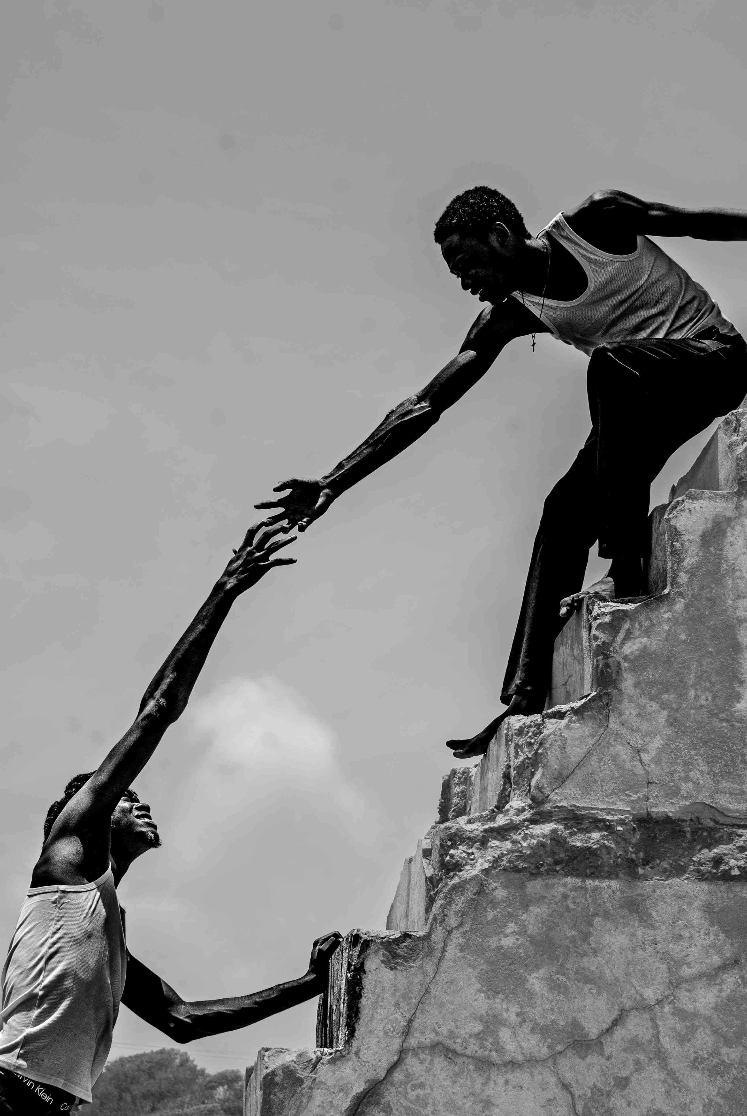 Two men reaching for each others hand